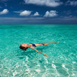 Woman in bikini lying on water