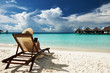 Foto: Young woman with tablet pc at the beach Young woman with tablet pc at the beach