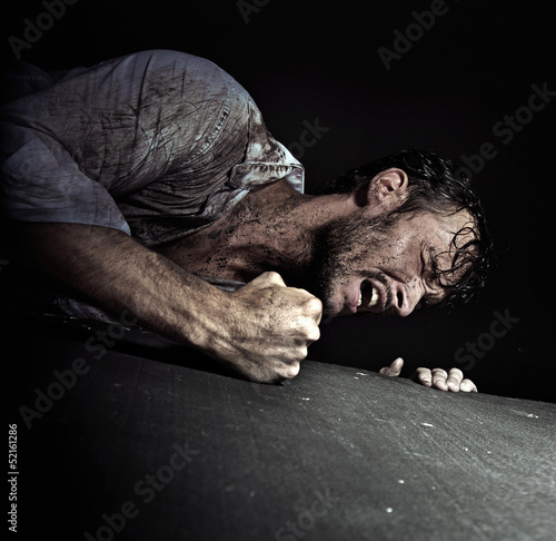 Photo: Resigned handsome man hitting the floor Resigned handsome man hitting the floor