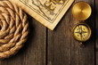 Antique compass and rope over old map
