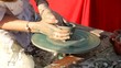 Woman hands shaping clay pot until it spins on a circular base