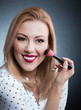 Woman applying cosmetics to her face