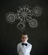 Boy dressed as business man chalk turning gear cogs