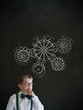 Boy dressed as businessman chalk turning gear cogs