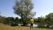 Man arrive at river bank and lying on the grass under the tree