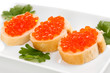 Red caviar on bread on white plate isolated on white