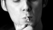 Man lighting up a cigarette in black and white
