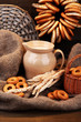 jar of milk, tasty bagels and spikelets on wooden background