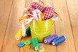 Color bucket with multicolor ribbons and thread