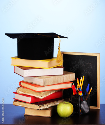 Photo: Books and magister cap against school board Books and magister cap against school board