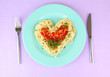 Cooked spaghetti carefully arranged in  heart shape and topped