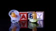 Pacifiers falling in front of blocks spelling baby