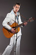 Retro rock and roll singer with guitar wearing white suit. Studi