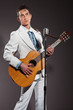 Retro rock and roll singer with guitar wearing white suit. Studi