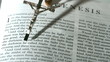 Rosary beads falling onto the book of genesis
