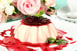 Panna Cotta with raspberry sauce, on color wooden background