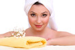 Beautiful young woman with flowers and towel
