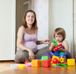Photo: Happy pregnant mother plays with child Happy pregnant mother plays with child