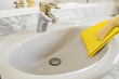 gray sink cleaning with yellow gloves