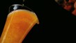 Beer pouring into glass on black background low angle view