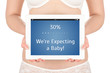 A pregnant woman is holding a tablet computer
