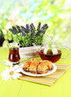 Sweet baklava on plate with tea on table on bright background