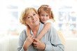 Photo: Smiling young girl hugging her grandmother Smiling young girl hugging her grandmother