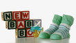 Blue soother falling besides slippers and baby blocks