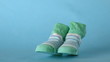 Green slippers falling on blue background