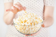 Girl holding a glass bowl of popcorn