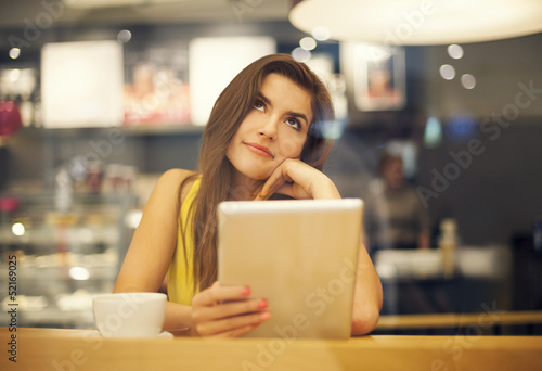 Photo: Young woman dreaming in cafe . Young woman dreaming in cafe .