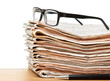 Glasses on a stack of newspapers