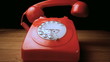 Red receiver falling onto retro dial phone