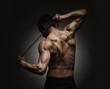Photo: Athlete stretching out over dark background Athlete stretching out over dark background