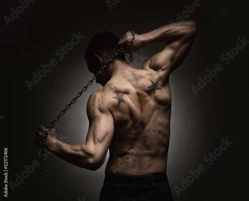 Photo: Athlete stretching out over dark background Athlete stretching out over dark background