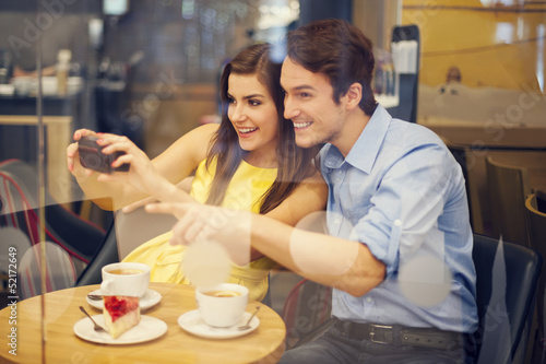 Photo: Happy couple taking photo in cafe Happy couple taking photo in cafe