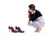 Foto: Junge Frau schaut Schuhe an Junge Frau schaut Schuhe an
