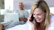 Video: Woman laughing on the phone, next to his husband on his laptop Woman laughing on the phone, next to his husband on his laptop