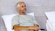 Man sitting in his bed while watching television