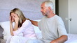 Husband comforting his wife on the bed