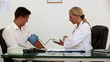 Female doctor checking patient blood pressure