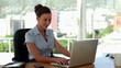 Smiling businesswoman typing on laptop