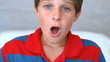 Surprised blue eyed boy opening his mouth