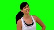 Woman in sportswear tossing her hair on green screen