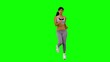 Athletic woman jogging on green screen in slow motion