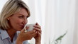 Relaxed woman drinking a cup of tea in her living room
