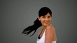 Fit brunette smiling at the camera and tossing her hair