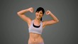 Fit brunette showing her arm muscles on grey background