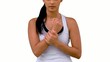 Fit woman massaging her sore wrist on white background