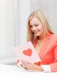 woman holding postcard with heart shape